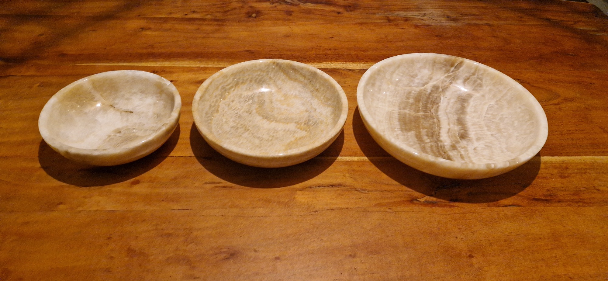 Luxe 3-delige onyx schalenset van gepolijst natuursteen met unieke wit en bruine patronen, formaten 30cm, 25cm en 20cm, vrijstaand op witte achtergrond. - view 4