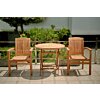 Twee teakhouten, stapelbare Ibiza tuinstoelen staan naast een vierkante, deels ingeklapte teakhouten tuintafel op een zonnig terras.