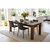 Deze sfeervolle setting toont hoe een robuuste houten tafel een warm ankerpunt vormt in een licht en modern interieur. De combinatie van natuurlijke materialen en strakke designstoelen creëert een uitnodigende plek voor zowel dagelijks gezinsgebruik als s