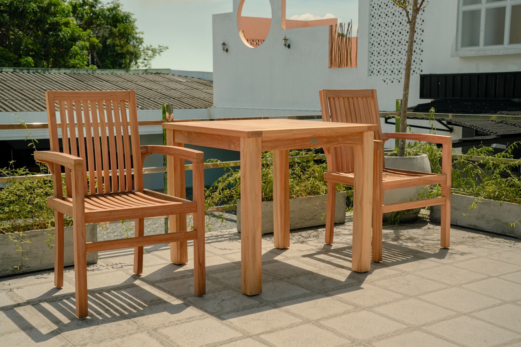 Moderne teakhouten tuinset met twee stapelbare Pile stoelen aan een vierkante, vaste tuintafel, stijlvol opgesteld op een terras. - alternate view