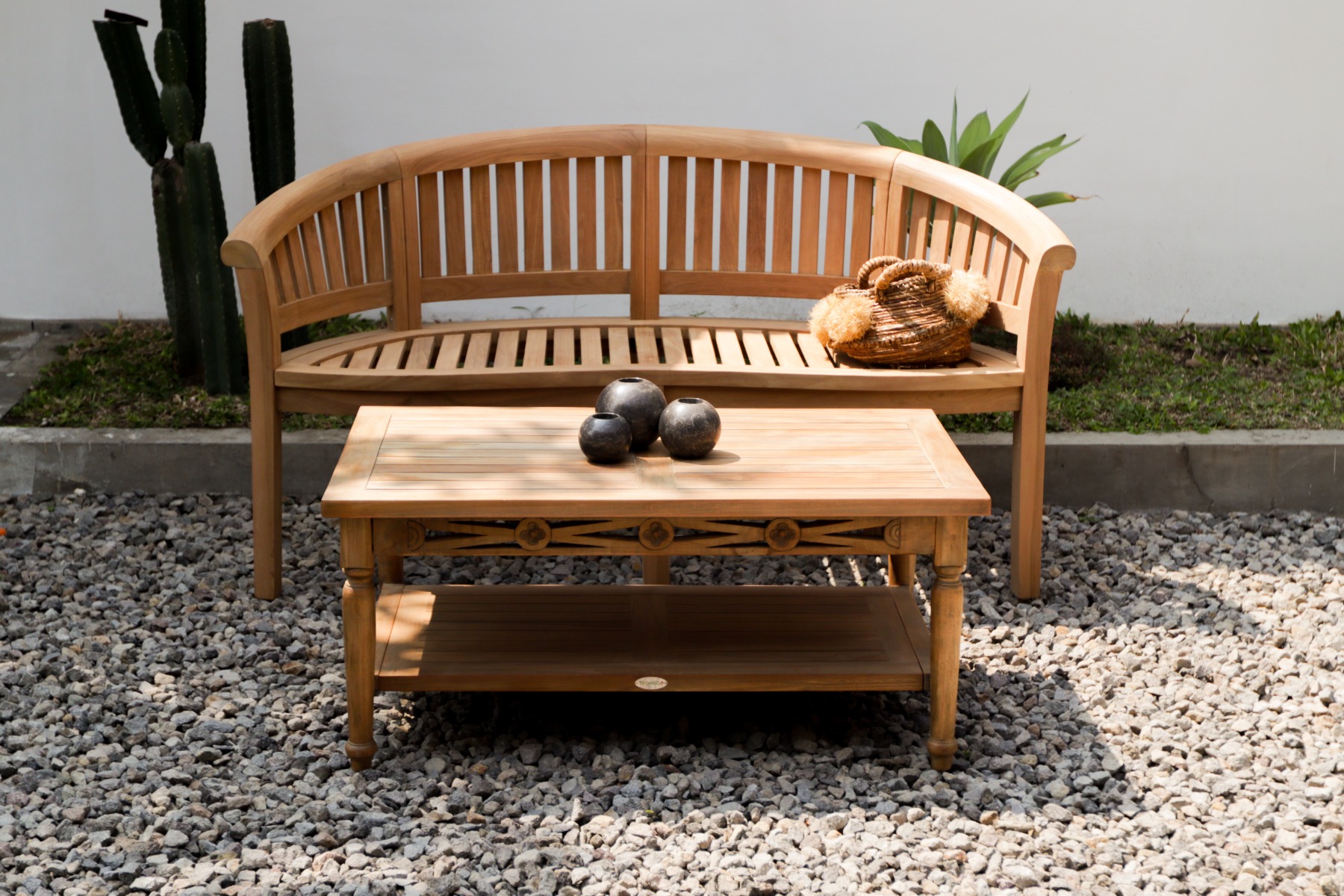 Halfronde teakhouten tuinbank met verticale lattenrug, gestyled met een plaid en kussens op een klinkert terras. - view 3