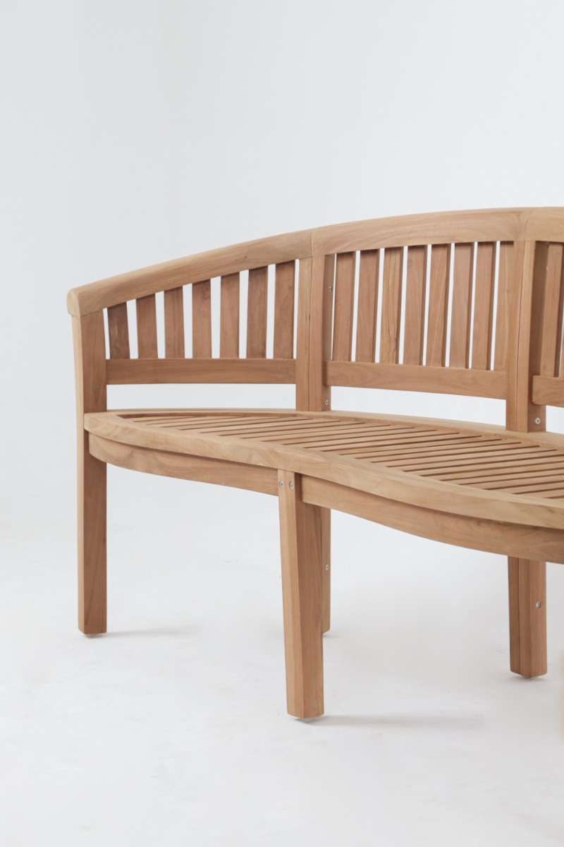 Halfronde teakhouten tuinbank met verticale lattenrug, gestyled met een plaid en kussens op een klinkert terras. - view 4