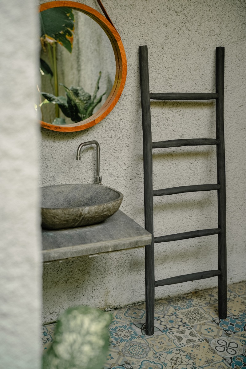 Een matzwarte houten decoratieladder, 150 cm hoog, 50 cm breed en 5 cm diep. De ladder heeft meerdere sporten met gelijkmatige tussenruimtes en staat licht hellend voor stabiliteit. De afwerking is glad en egaal, wat het minimalistische design benadrukt.  - alternate view