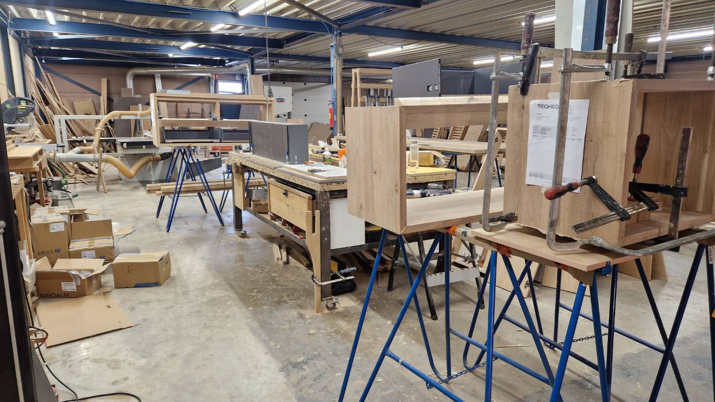Behind the showroom two - Teakea Coatingafdeling van Teakea met eiken kastdelen in de lijmklemmen op werkbanken
